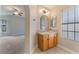 Ensuite bathroom featuring a granite countertop, wood cabinets, and updated lighting at 4817 Friar Ln, Las Vegas, NV 89130