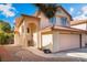 Charming exterior showcasing a home with an arched entryway and a two-car garage, beautifully landscaped at 4817 Friar Ln, Las Vegas, NV 89130