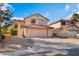 Exterior view of a charming two-story home with desert landscaping and an attached two-car garage at 4817 Friar Ln, Las Vegas, NV 89130