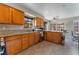 Well-lit kitchen with tile flooring, wood cabinets, granite countertops, and stainless steel appliances at 4817 Friar Ln, Las Vegas, NV 89130
