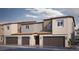 New construction townhomes with neutral paint, brown garage doors, and desert landscaping welcome you home at 4828 Lilac Ridge Ave # 26, Las Vegas, NV 89141