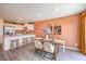 A dining area is attached to a kitchen with white cabinets and stainless steel appliances and an island at 4828 Lilac Ridge Ave # 26, Las Vegas, NV 89141