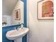 Stylish powder room features pedestal sink, painted accent wall, and wall art at 4828 Lilac Ridge Ave # 26, Las Vegas, NV 89141