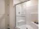 Modern shower featuring sleek white tiling, a corner seat, and a glass door at 4828 Lilac Ridge Ave # 26, Las Vegas, NV 89141