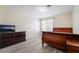 Comfortable bedroom with laminate floors, TV and window at 4869 S Torrey Pines Dr # 101, Las Vegas, NV 89103