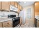 Efficient kitchen featuring light cabinets, white appliances, and tiled countertops at 4869 S Torrey Pines Dr # 101, Las Vegas, NV 89103