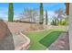 Landscaped backyard featuring a small lawn, brick border and privacy wall at 4920 River Splash Ave, Las Vegas, NV 89131