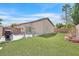 Backyard with a well manicured artificial lawn, brick accents, and patio with outdoor seating at 4920 River Splash Ave, Las Vegas, NV 89131
