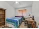 Cozy bedroom with a ceiling fan, window blinds, and a wooden desk, complete with a bed and a bedside bookshelf at 4920 River Splash Ave, Las Vegas, NV 89131