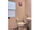 Neutral half bathroom with a toilet, art, a window and gray flooring at 4993 Birchland Manor Ave, Las Vegas, NV 89139