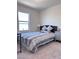 Bright bedroom with a large window and a comfortable bed with stylish bedding and a nightstand at 4993 Birchland Manor Ave, Las Vegas, NV 89139