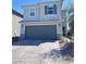 Charming two-story home featuring a two-car garage, light blue paint, and tidy landscaping at 4993 Birchland Manor Ave, Las Vegas, NV 89139