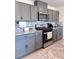 Updated kitchen featuring gray cabinets, stainless steel appliances, granite countertops, and stylish backsplash tiles at 4993 Birchland Manor Ave, Las Vegas, NV 89139