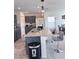 Open-concept kitchen featuring gray cabinets, granite countertops, stainless appliances, and a kitchen island with seating at 4993 Birchland Manor Ave, Las Vegas, NV 89139