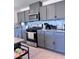 Updated kitchen featuring gray cabinets, stainless steel appliances, granite countertops, and stylish backsplash tiles at 4993 Birchland Manor Ave, Las Vegas, NV 89139