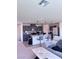 Open-concept living space with a kitchen, living room, and dining area with gray cabinets and granite countertops at 4993 Birchland Manor Ave, Las Vegas, NV 89139