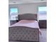 Spacious main bedroom featuring a luxurious upholstered bed frame, plush carpeting, and windows at 4993 Birchland Manor Ave, Las Vegas, NV 89139