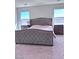 Spacious main bedroom featuring a luxurious upholstered bed frame, plush carpeting, and windows at 4993 Birchland Manor Ave, Las Vegas, NV 89139