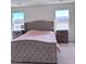 Spacious main bedroom featuring a luxurious upholstered bed frame, plush carpeting, and windows at 4993 Birchland Manor Ave, Las Vegas, NV 89139
