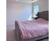 Comfortable main bedroom featuring a luxurious upholstered bed frame, plush carpeting, and windows at 4993 Birchland Manor Ave, Las Vegas, NV 89139