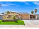 Inviting single-story home with a well-manicured lawn, mature palm trees, and a convenient attached carport at 5001 Morris St, Las Vegas, NV 89122