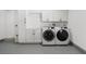 Well-lit laundry room featuring front loading washer and dryer, and storage cabinets at 5001 Morris St, Las Vegas, NV 89122