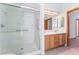 Bright bathroom featuring double sink vanity and frameless glass shower with grab bars at 5029 Pacific Grove Dr, Las Vegas, NV 89130