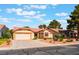 Charming one-story home featuring a well-maintained lawn, two-car garage, and desert landscaping at 5029 Pacific Grove Dr, Las Vegas, NV 89130