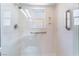 Modern shower with glass enclosure, grab bars, handheld shower, and natural light from window at 5029 Pacific Grove Dr, Las Vegas, NV 89130