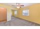 A bright bedroom with yellow walls, carpet, ceiling fan and mirrored closet at 5231 E Chasemoor St, Pahrump, NV 89061
