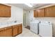 A bright laundry room featuring tile floors, sink, and washer/dryer units at 5231 E Chasemoor St, Pahrump, NV 89061
