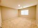 Spacious carpeted bedroom illuminated by a central ceiling light fixture and a bright window at 5271 Aurora Beam Ave, Las Vegas, NV 89122