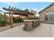 Backyard barbecue grill with stone surround, patio, and pergola at 6012 Chessington Ave, Las Vegas, NV 89131