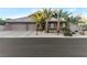 Charming home exterior featuring a three-car garage and lush palm tree landscaping at 6012 Chessington Ave, Las Vegas, NV 89131