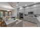 Modern kitchen featuring gray cabinets, stainless steel appliances, a breakfast bar, and stone accent wall at 6012 Chessington Ave, Las Vegas, NV 89131