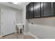 Laundry room featuring utility sink, cabinets, and tile flooring at 6012 Chessington Ave, Las Vegas, NV 89131
