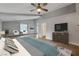 Spacious primary bedroom with modern decor, a ceiling fan, tile flooring, and access to an ensuite bathroom at 6012 Chessington Ave, Las Vegas, NV 89131