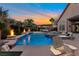 A luxurious pool area with cascading waterfalls, a hot tub, and poolside seating, perfect for relaxation at 6012 Chessington Ave, Las Vegas, NV 89131
