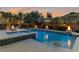 An alluring pool and spa area featuring water features, lush landscaping, and ambient lighting for a tranquil retreat at 6012 Chessington Ave, Las Vegas, NV 89131