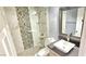 Modern bathroom with tiled shower, glass doors, contemporary fixtures, and gray vanity at 6348 Blue Twilight Ct, Las Vegas, NV 89108