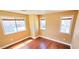 A cozy bedroom with three windows providing ample natural light and hardwood floors at 6348 Blue Twilight Ct, Las Vegas, NV 89108