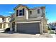 Two-story tan home with a two-car garage, brown shutters, and well-kept landscaping at 6348 Blue Twilight Ct, Las Vegas, NV 89108