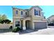 Two-story tan home with a two-car garage, covered entry, and well-kept landscaping at 6348 Blue Twilight Ct, Las Vegas, NV 89108