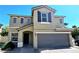 Two-story tan home with a two-car garage, covered entry, and neatly trimmed landscaping at 6348 Blue Twilight Ct, Las Vegas, NV 89108