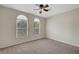 Bright bedroom with neutral walls, carpet and two arched windows at 7216 Campolina Ct, Las Vegas, NV 89113