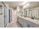 Modern bathroom with double sinks, granite counters, and glass-enclosed shower at 7477 Onyx Star St, North Las Vegas, NV 89084