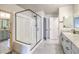 Bathroom featuring dual sink vanity, framed mirror, and glass enclosed shower at 7477 Onyx Star St, North Las Vegas, NV 89084