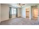 Bedroom with walk-in closet and ensuite bath, neutral walls, carpet, ceiling fan, and natural light at 7477 Onyx Star St, North Las Vegas, NV 89084