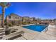 Community swimming pool with lounge chairs, surrounded by modern homes and a security fence at 7477 Onyx Star St, North Las Vegas, NV 89084