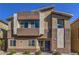 Modern two-story home featuring a blue front door, neutral color palette, and desert landscaping at 7477 Onyx Star St, North Las Vegas, NV 89084